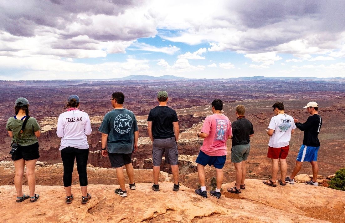 The Texas A&M geology field camp cohort lined up along a canyon rim